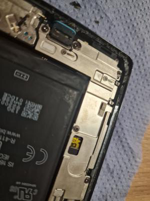 Black textured adhesive around the inner perimeter of a phones inside